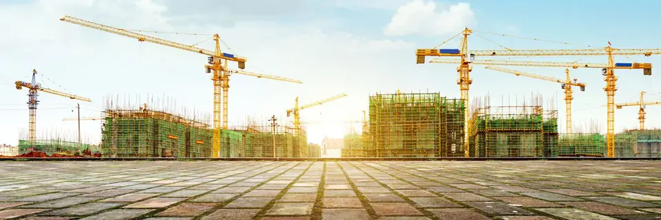 Baustelle mit Kränen bei Sonnenuntergang