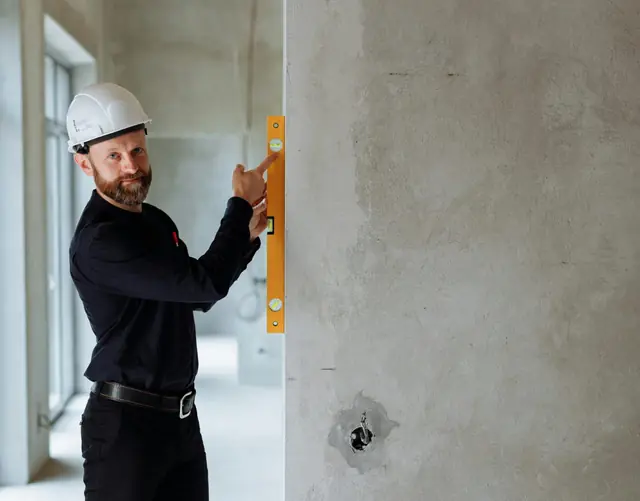Handwerker prüft eine Wand mit der Wasserwaage